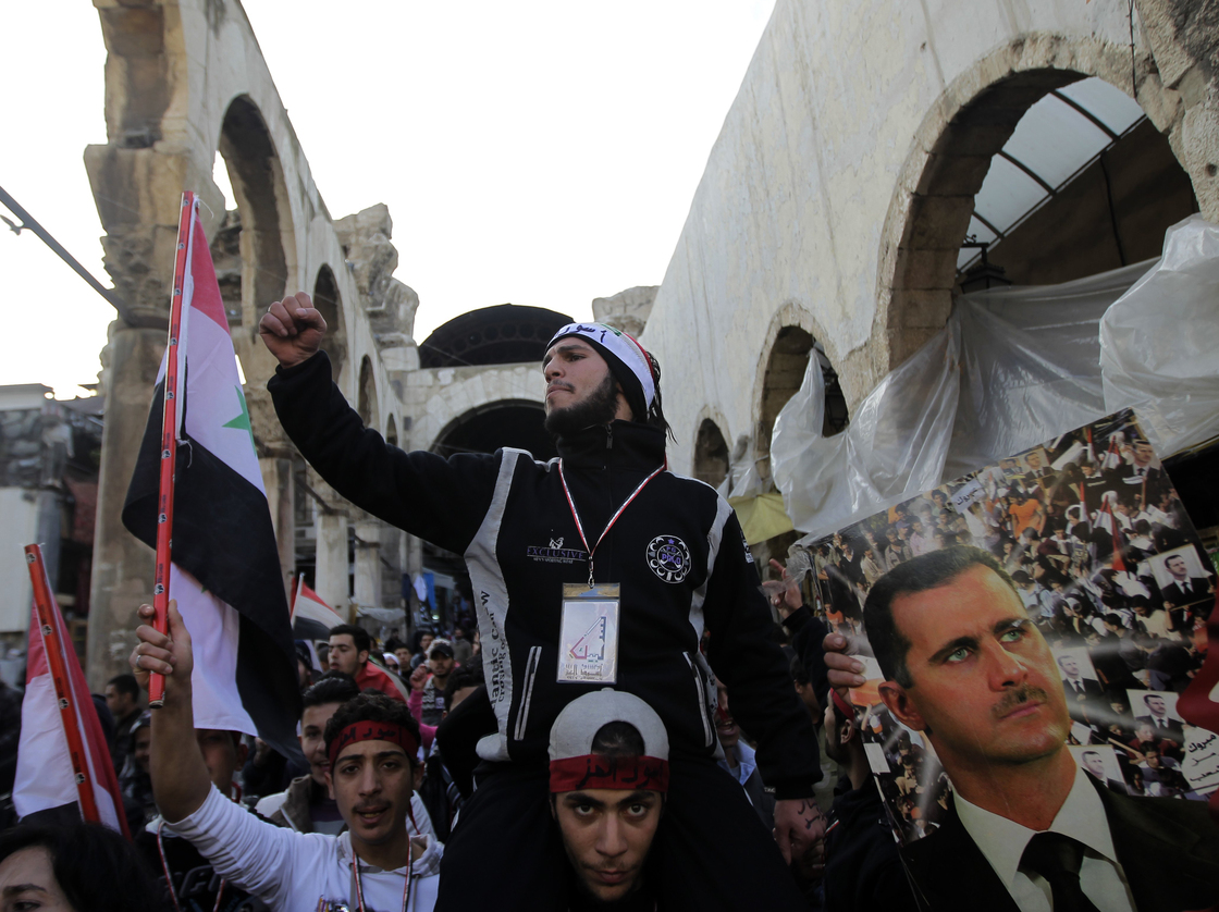 Assad supporters chant pro-government slogans as they rally in Hamidiyah Jan. 10. But that support is crumbling, evidenced by a strike by the market's merchants to protest killings in Houla, Syria.