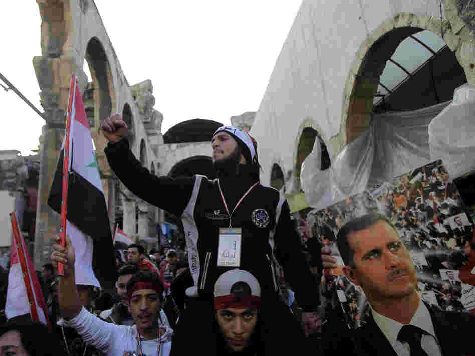Assad supporters chant pro-government slogans as they rally in Hamidiyah Jan. 10. But that support is crumbling, evidenced by a strike by the market's merchants to protest killings in Houla, Syria.