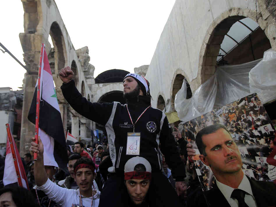 Assad supporters chant pro-government slogans as they rally in Hamidiyah Jan. 10. But that support is crumbling, evidenced by a strike by the market's merchants to protest killings in Houla, Syria.