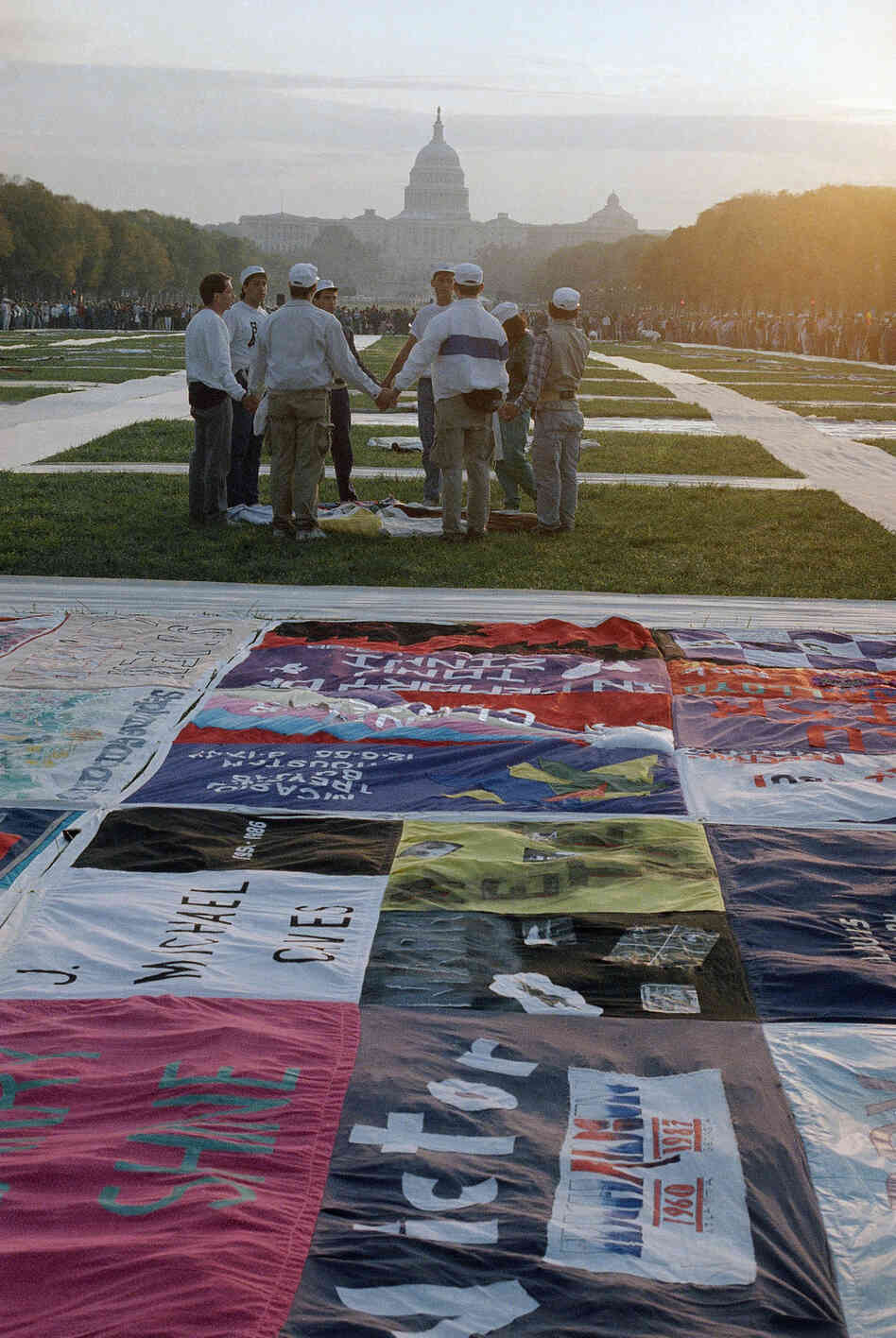 A sunrise ceremony is held in 1987 in Washington, near part of the quilt bearing the names of people who have died of AIDS.