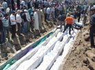 May 26, 2012: In this picture provided by the Syrian opposition's Shaam News Network, people watch the mass burial of victims in Houla. May 26, 2012: In this picture provided by the Syrian opposition's Shaam News Network, people watch the mass burial of victims in Houla.