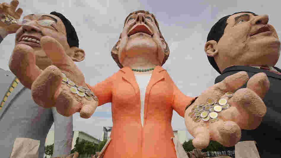 Critics of Germany's spending policy created effigies of Chancellor Angela Merkel (center) and other German leaders to stand near the chancellery in Berlin.
