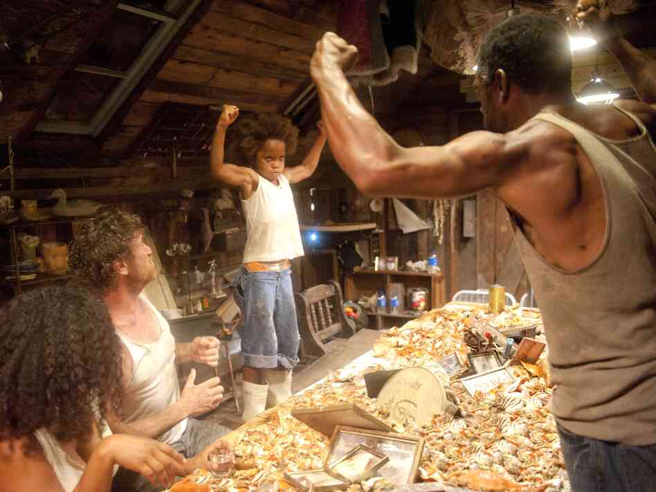 Much as playwright Lucy Alibar's father once did, Hushpuppy's father, played by Dwight Henry (right), encourages his daughter (Wallis) to be tough and strong by saying things like, "Show me your guns."