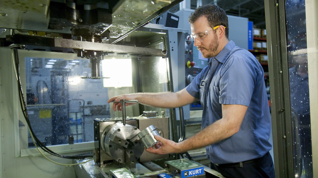 Brian Gasiewski removes the external housing for an industrial shock absorber from a CNC, or computer numerical control, machine at Fitzpatrick Manufacturing Co. in Sterling Heights, Mich.