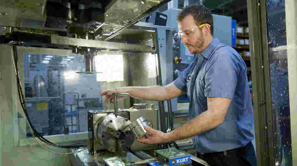 Brian Gasiewski removes the external housing for an industrial shock absorber from a CNC, or computer numerical control, machine at Fitzpatrick Manufacturing Co. in Sterling Heights, Mich.