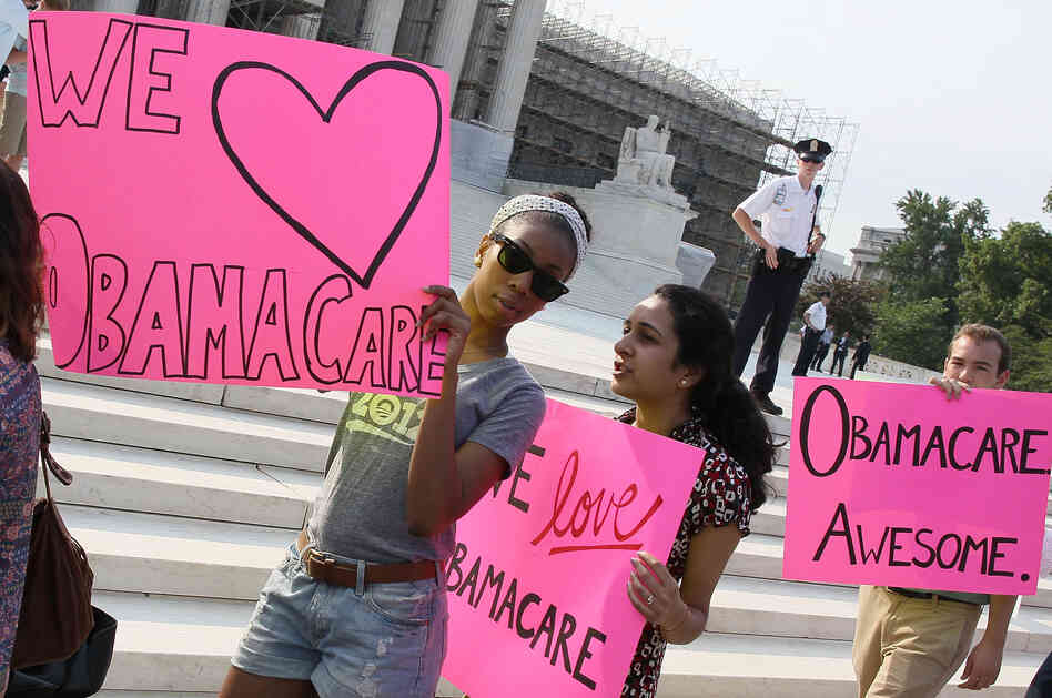 Supporters of the health care law march in front of the Supreme Court building.