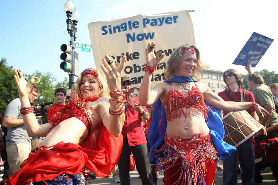 Two supporters of the law belly-dance as they demonstrate in front of the Supreme Court.