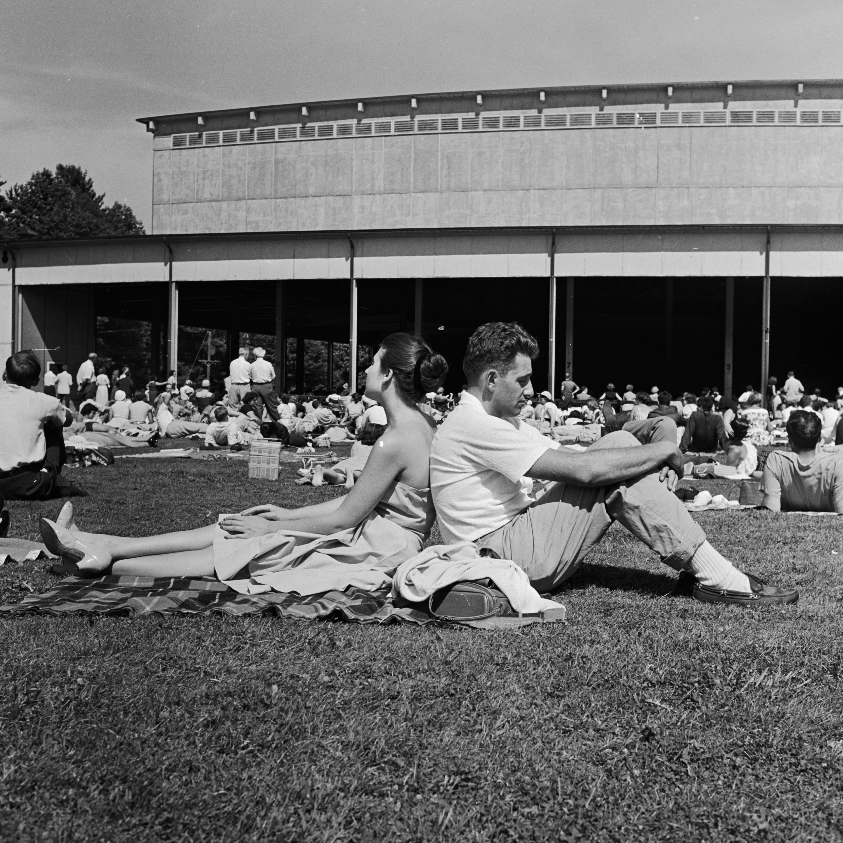 A couple seated on Tanglewood's lawn listens to the Boston Symphony Orchestra play Brahms, circa 1960.