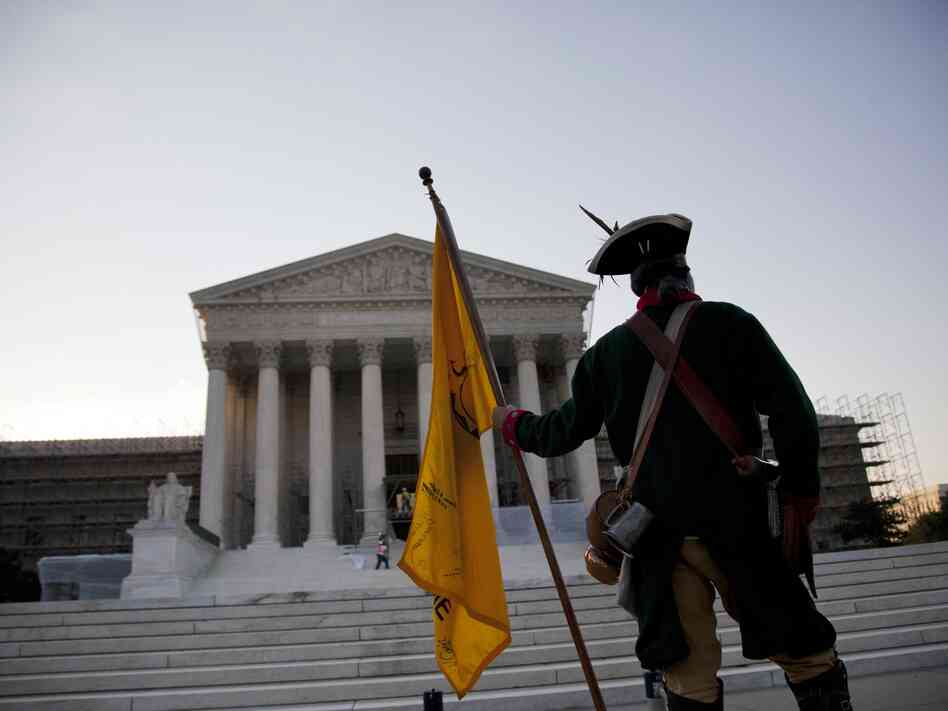 William Temple of Brunswick, Ga., waits for the Supreme Court's decision early Thursday. The landmark health care decision that came later ended just one chapter in the nation's long partisan war.