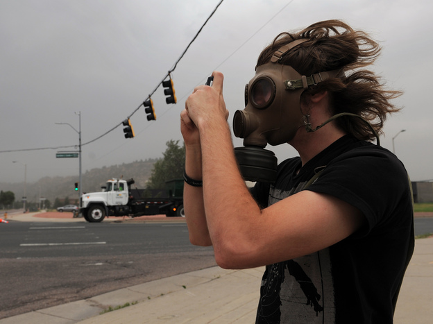 Mikke Carlson took photos of the smoke from the Waldo Canyon fire while wearing a gas mask on Wednesday in Colorado Springs, Colo.