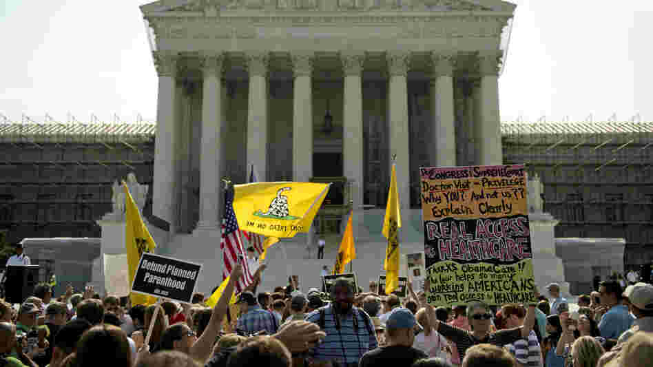 Protesters and supporters of President Obama's health care law await the Supreme Court's ruling Thursday. The court ruled to uphold the law. The focus now shifts to the states, which are responsible for the lion's share of getting people without insurance covered.