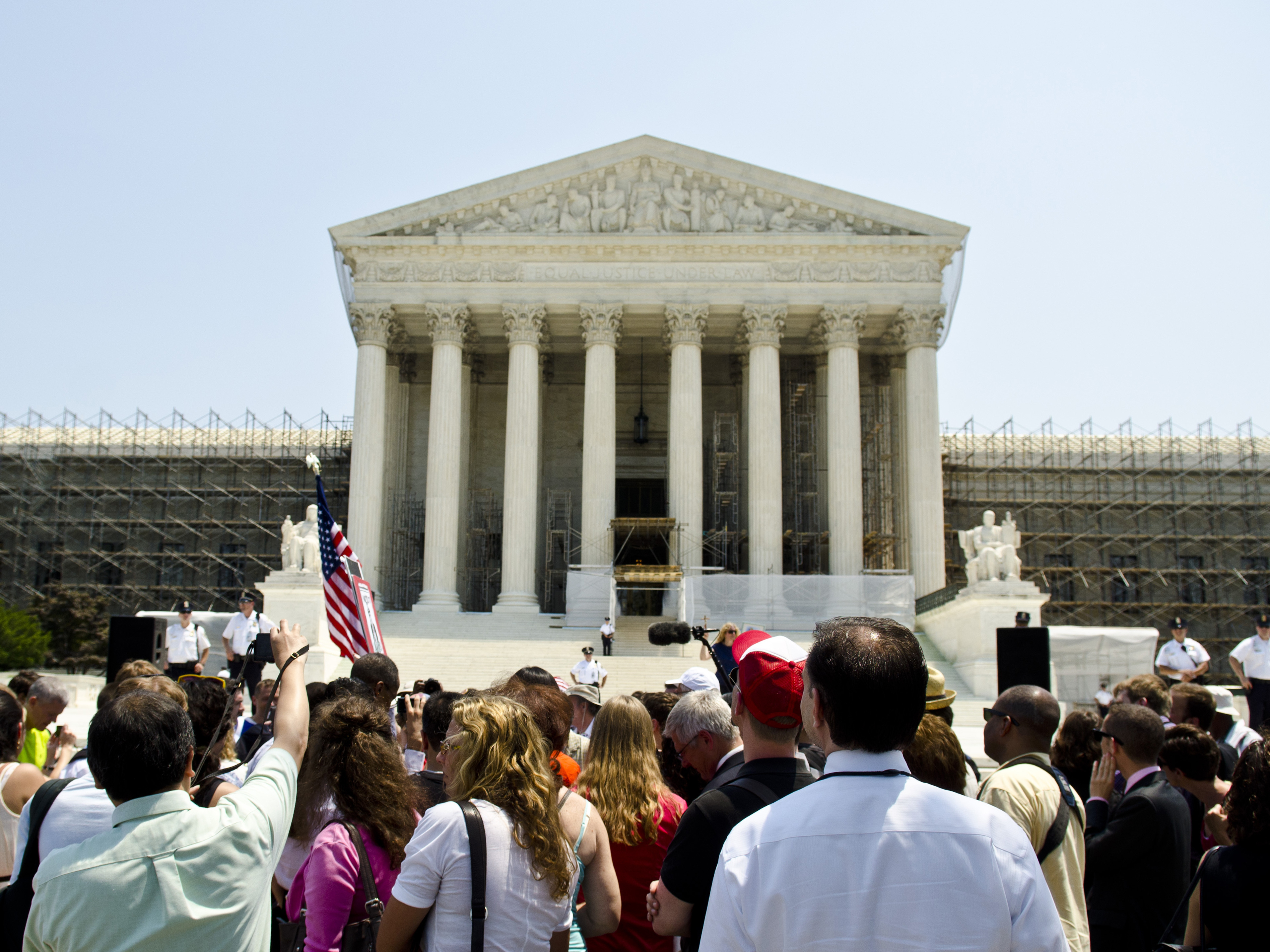 Protesters stand outside the U.S. Supreme Court on Thursday. The court's ruling upholding the federal health care law is expected to have wide-reaching implications for businesses. (Image credit: Getty Images)