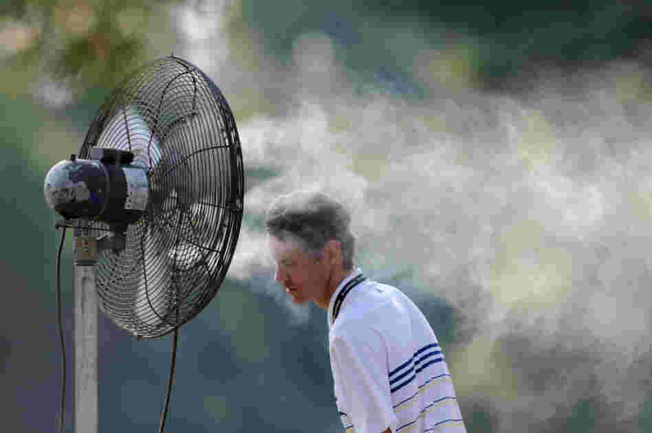 A spectator cools off with a spray mist during first round play Friday at the AT&T National at Congressional Country Club in Bethesda, Md. 