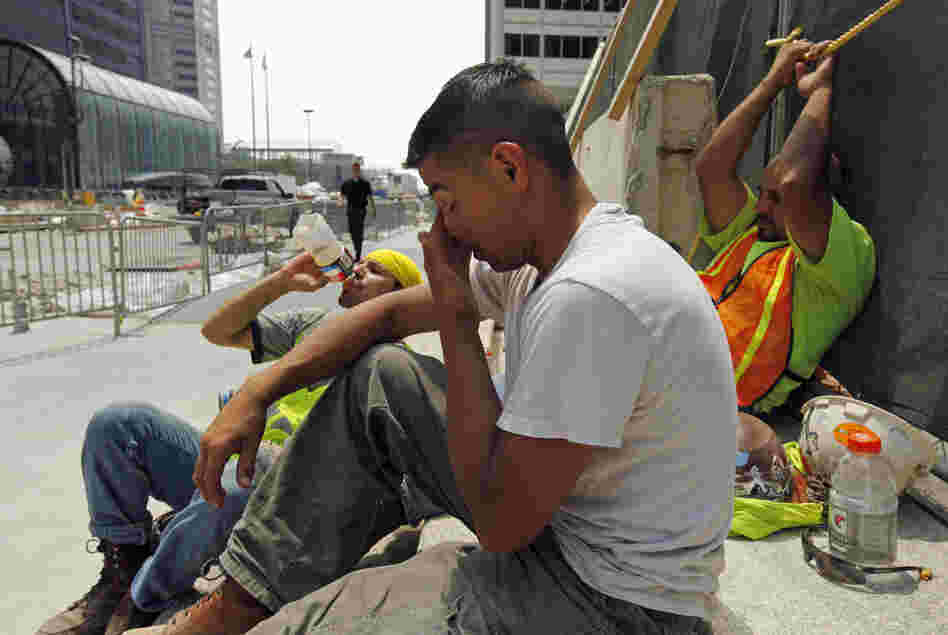 From left, construction workers Santiago Gomez, Jorge Moreno and Abel Lozano take a break from the extreme heat during a road construction project in downtown Chicago, Thursday. Little relief from the heat is expected in the next few days.