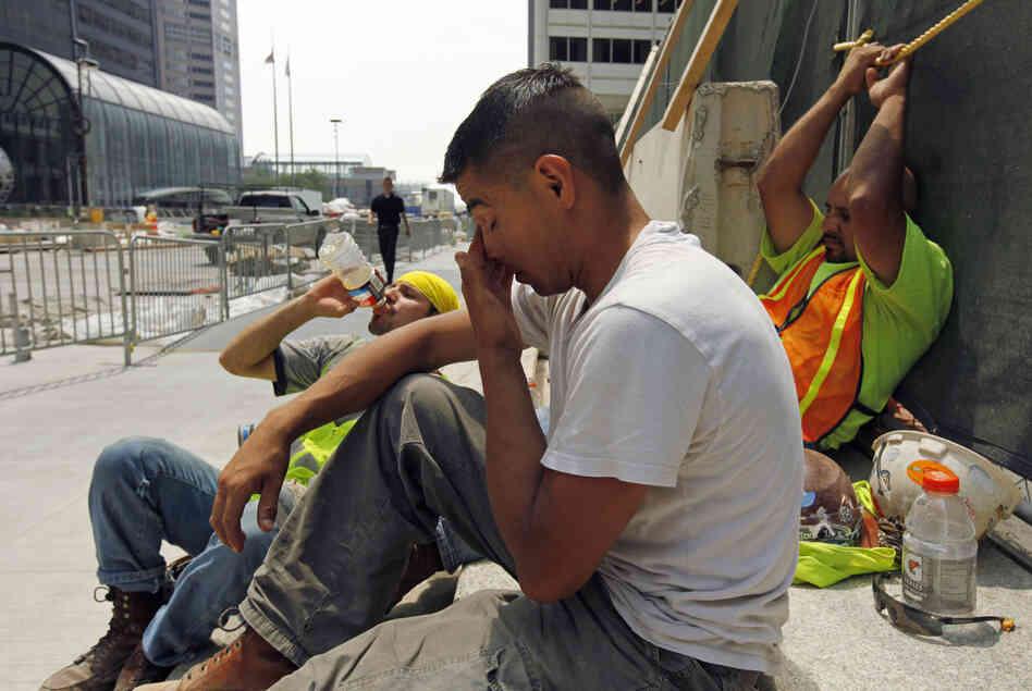 From left, construction workers Santiago Gomez, Jorge Moreno and Abel Lozano take a break from the extreme heat during a road construction project in downtown Chicago, Thursday. Little relief from the heat is expected in the next few days.