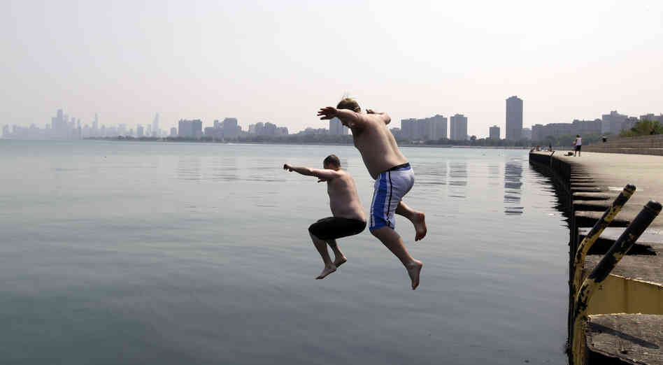 Jason Gerald (left) and Adam Hoffman jump into the Lake Michigan at Montrose Beach in Chicago on Thursday. 