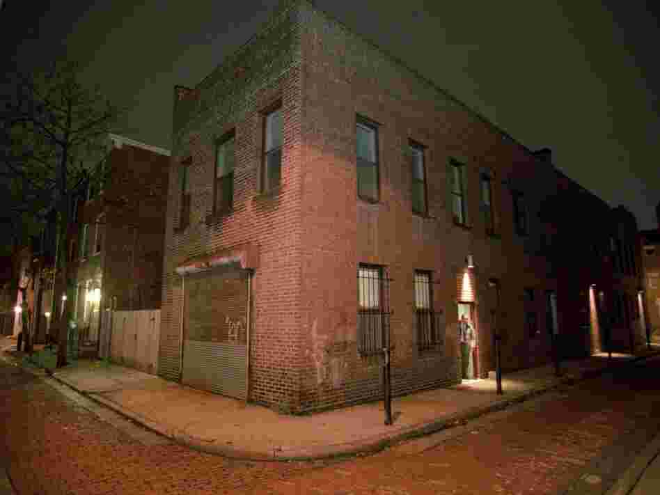 A detective peers from the doorway of a Center City Philadelphia apartment building.