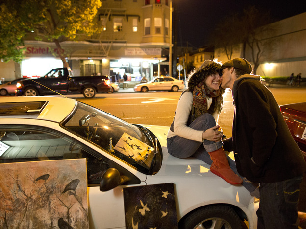 Ryan Curtis leans in for a kiss from Love Kovtun on Telegraph Avenue in Oakland's Uptown neighborhood in April. New businesses and investment have helped revitalize the city's downtown over the past decade.