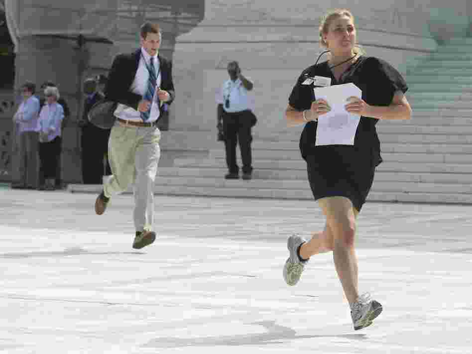 Reporters sprint from the Supreme Court after a majority of the justices upheld the constitutionality of the Affordable Care Act.
