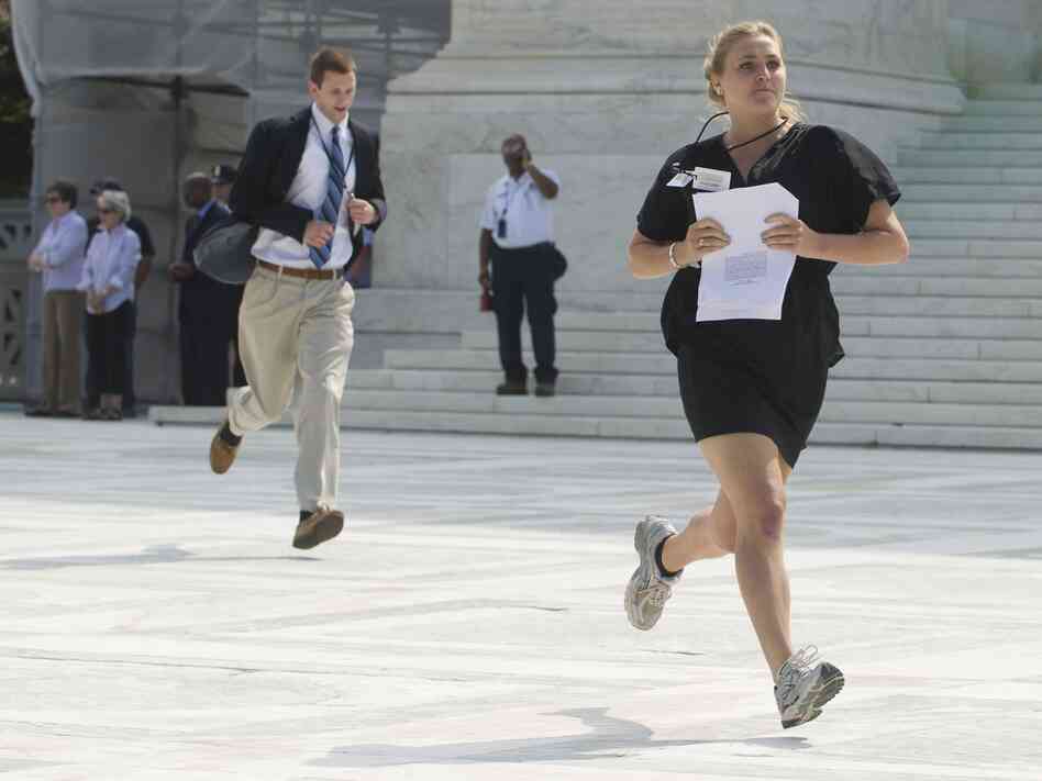 Reporters sprint from the Supreme Court after a majority of the justices upheld the constitutionality of the Affordable Care Act.
