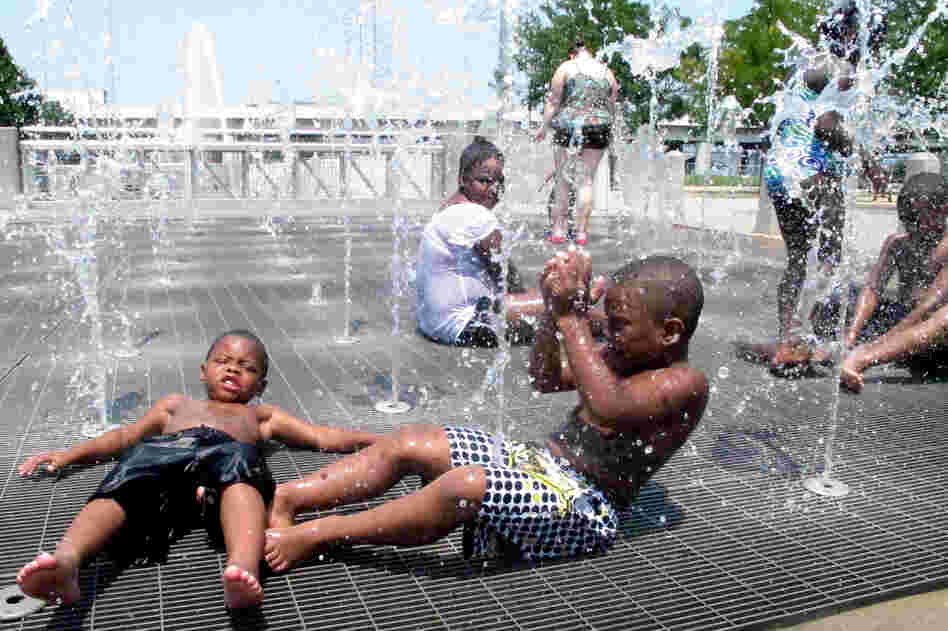 Children cool off from the intense heat at a waterfront park in downtown Louisville, Ky., on Friday.