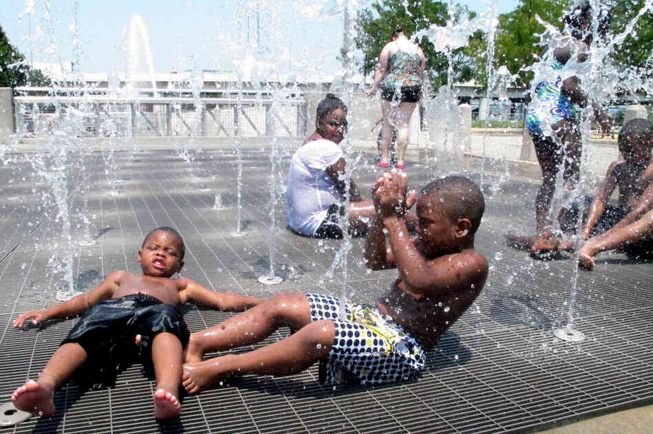 Children cool off from the intense heat at a waterfront park in downtown Louisville, Ky., on Friday.