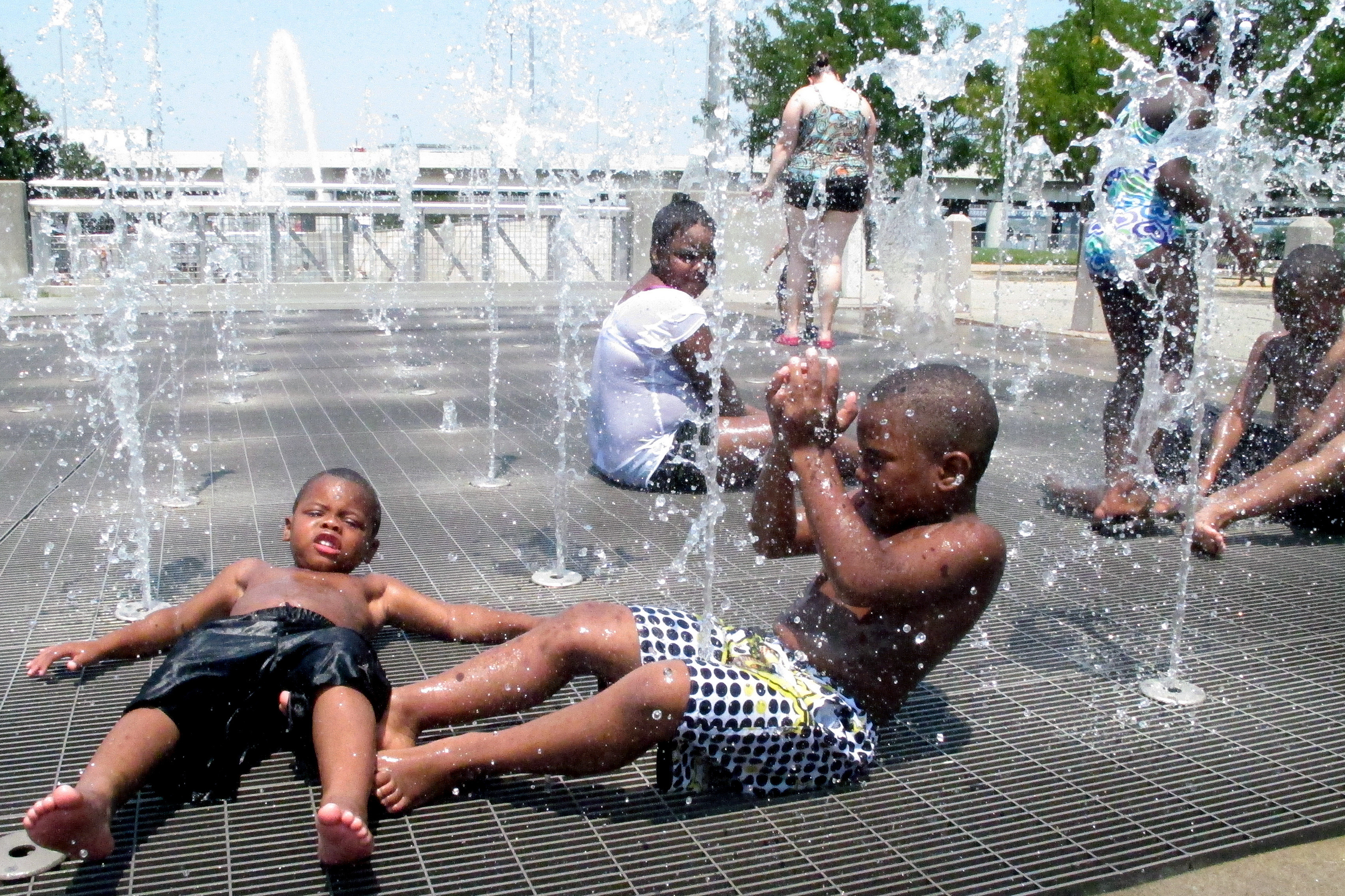 Children cool off from the intense heat at a waterfront park in downtown Louisville, Ky., on Friday.