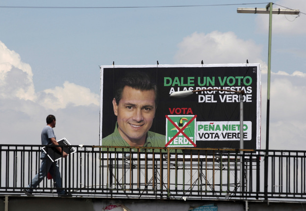A man walks past a campaign sign for Enrique Pena Nieto, of the opposition Institutional Revolutionary Party. Mexicans vote for their next president on Sunday.