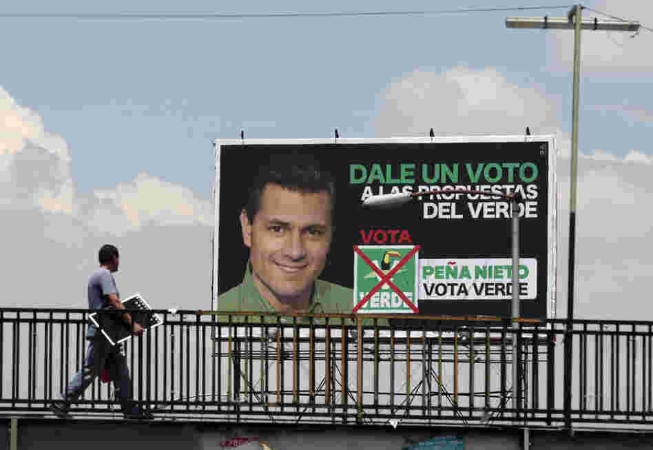 A man walks past a campaign sign for Enrique Pena Nieto, of the opposition Institutional Revolutionary Party. Mexicans vote for their next president on Sunday.