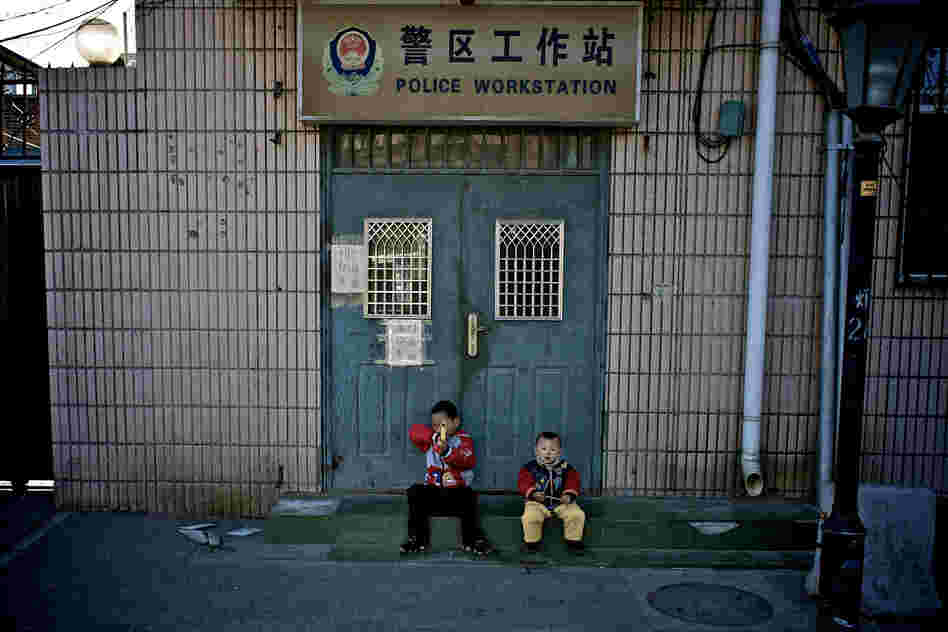 "Two small boys playing outside a local police station."