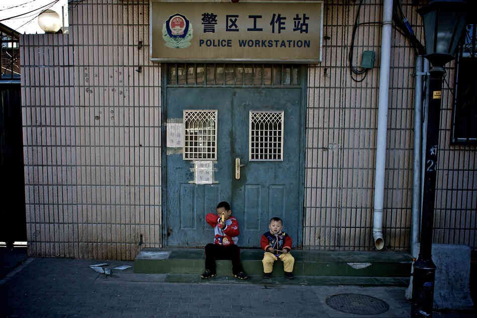 "Two small boys playing outside a local police station."