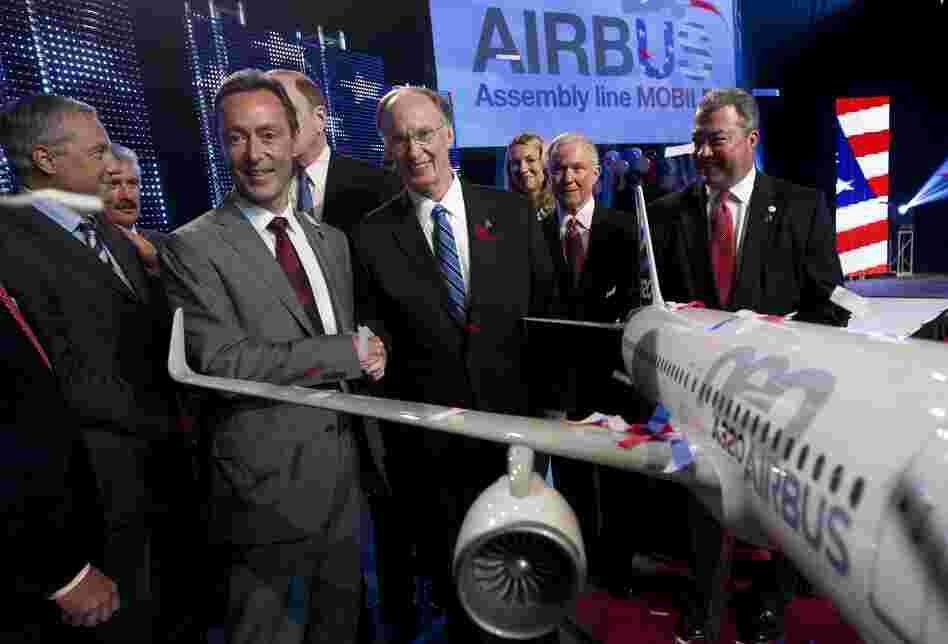 Airbus President & CEO Fabrice Bregier, second from left, shakes hands with Alabama Gov. Robert Bentley as they pose with a model of the A320 Airbus.