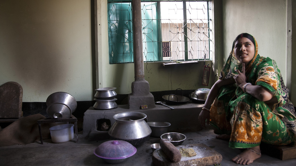 A woman at home in Bangladesh with an improved cookstove