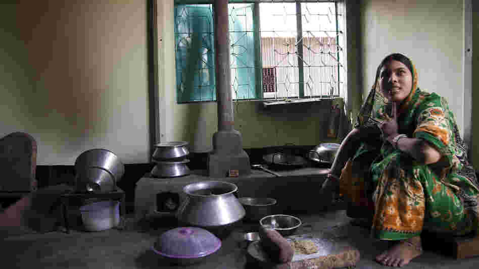A woman at home in Bangladesh with an improved cookstove