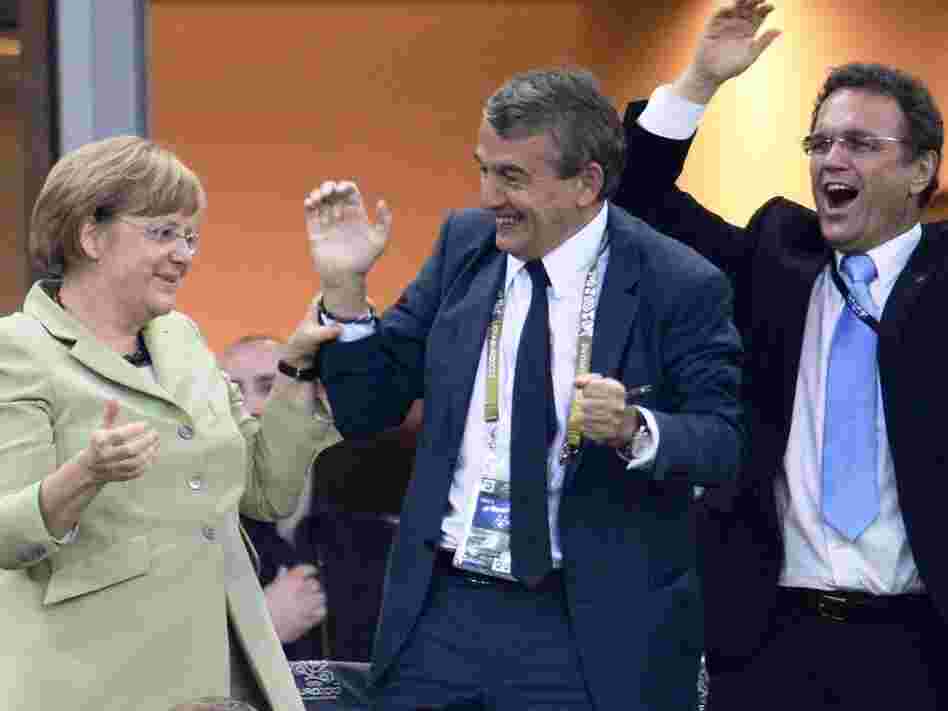 German Chancellor Angela Merkel, German football association president Wolfgang Niersbach and German Interior Minister Hans-Peter Friedrich celebrate after Philip Lahm scored against Greece during the Euro 2012
