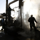 Iranian workers make repairs to a unit at Tehran's oil refinery in November 2007. It's estimated that a Western oil embargo is costing Iran about $4.5 billion each month in lost revenue. Iranian workers make repairs to a unit at Tehran's oil refinery in November 2007. It's estimated that a Western oil embargo is costing Iran about $4.5 billion each month in lost revenue.