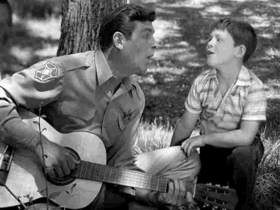 Andy Griffith as Sheriff Andy Taylor and Ron Howard as his son, "Opie" Taylor sing together in 1962. Andy Griffith as Sheriff Andy Taylor and Ron Howard as his son, "Opie" Taylor sing together in 1962.