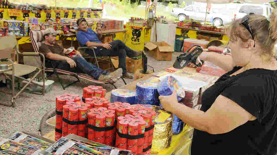 Susan Underwood prices fireworks, while her husband Michael (left) and Clint Simmons pace themselves with a snack and TV last month at their tent along Highway 416 in Sevier County, Tenn. Over in Middle Tennessee, the drought has led city leaders to ban fireworks this year. Susan Underwood prices fireworks, while her husband Michael (left) and Clint Simmons pace themselves with a snack and TV last month at their tent along Highway 416 in Sevier County, Tenn. Over in Middle Tennessee, the drought has led city leaders to ban fireworks this year.