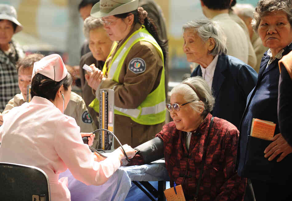 People wait to have their blood pressure checked in Shanghai in April. China's one-child policy is more than just a human rights issue; demographers warn that the low birth rate will result in a shortage of workers to drive the economy. People wait to have their blood pressure checked in Shanghai in April. China's one-child policy is more than just a human rights issue; demographers warn that the low birth rate will result in a shortage of workers to drive the economy.