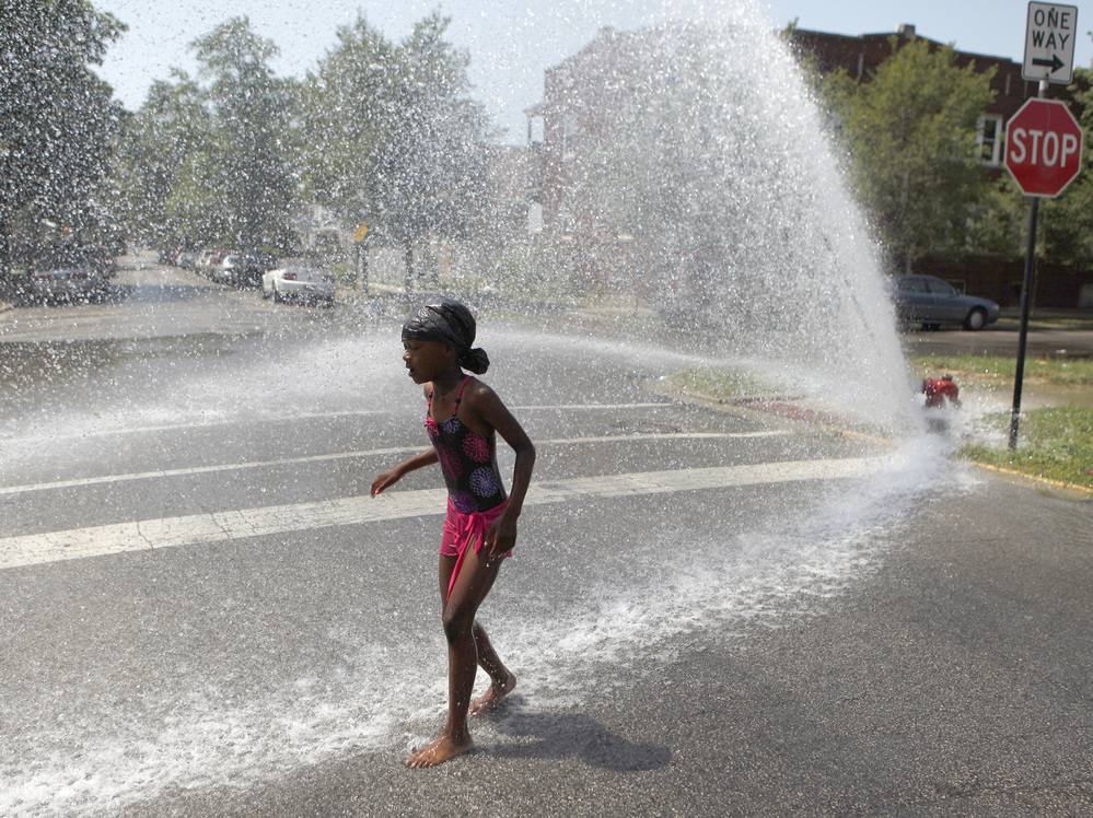 Trying to keep cool in Chicago: On Wednesday, 7-year-old Keshyra Pitts played in the spray from a fire hydrant.