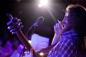 Ask Me Another's resident musician, the unstoppable Mr. Jonathan Coulton, pen in hand, works his improv magic on stage. Ask Me Another's resident musician, the unstoppable Mr. Jonathan Coulton, pen in hand, works his improv magic on stage.