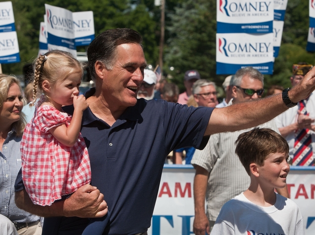 Republican presidential candidate Mitt Romney holds his granddaughter Soleil Romney as he walks in the Wolfeboro Independence Day parade on July 4, 2012 in Wolfeboro, New Hampshire.