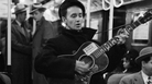 Woody Guthrie singing aboard a New York City subway train. Woody Guthrie singing aboard a New York City subway train.