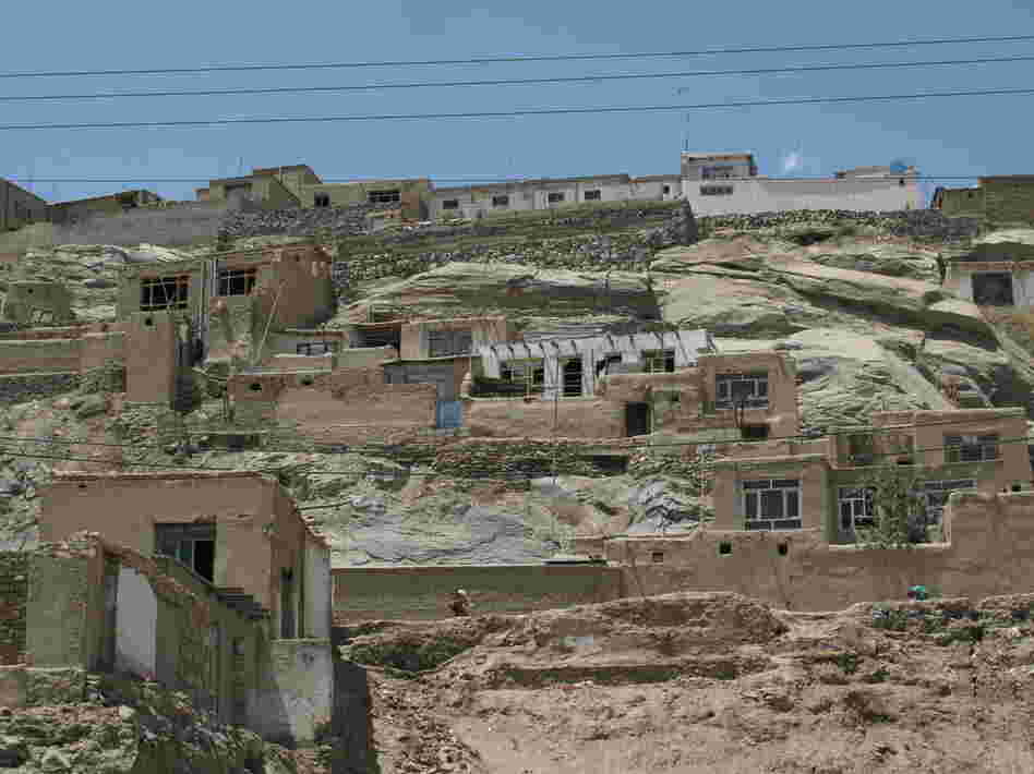Poorly constructed houses cling precariously to hillsides in Kabul. Such neighborhoods often lack electricity and running water.