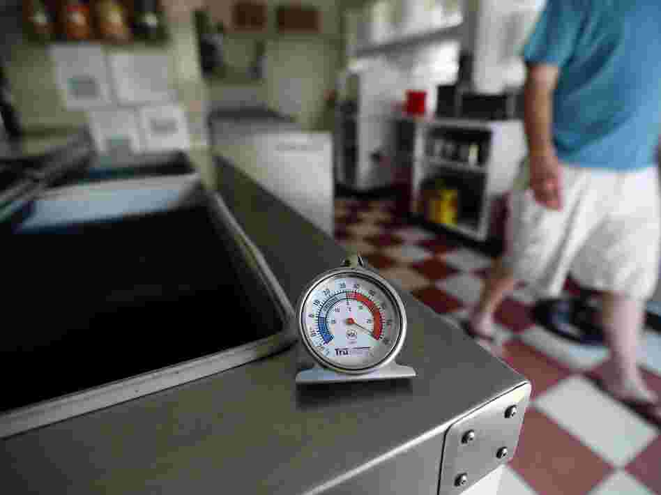 A thermometer reads the temperature atop an empty Maryland ice cream store freezer on Tuesday.  Many grocery stores and restaurants are still waiting for power to return for the first time since last weekend's severe storms.