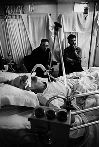 A black lung victim nears his last breath. His sons, also coal miners, keep vigil. In 1998, NIOSH estimated that 2,000 miners died annually from lung diseases caused by exposure to coal dust.
