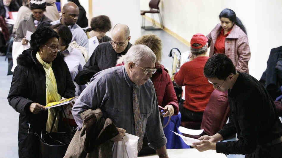John Pham (right) reviews Bob Drake's resume at an AARP event aimed at helping older workers improve their job search. Workers age 55 and older cite particular difficulty finding employment, and some are choosing to retrain for new careers.