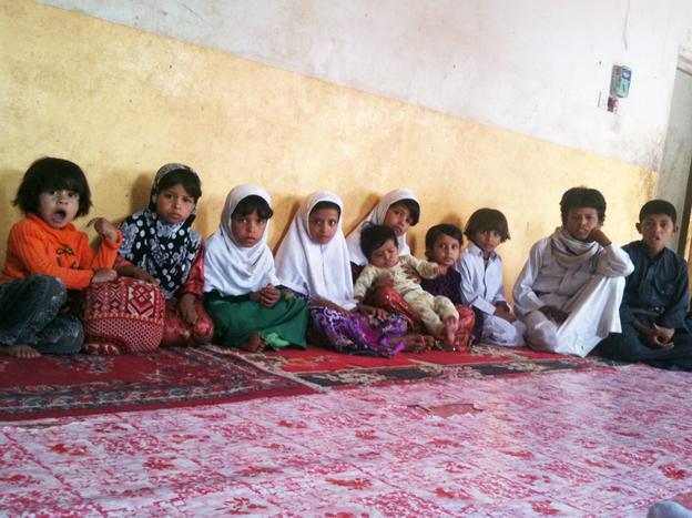 Some of the 26 children of Saleh Qaid Toayman, who was killed with one of his sons in an airstrike on Oct. 14, 2011. The family says the eldest son, Azzedine, has joined an al-Qaida-affiliated group to avenge the father's death. The group's black banner hangs in the family's home. The family says the militant group gives them a monthly stipend.