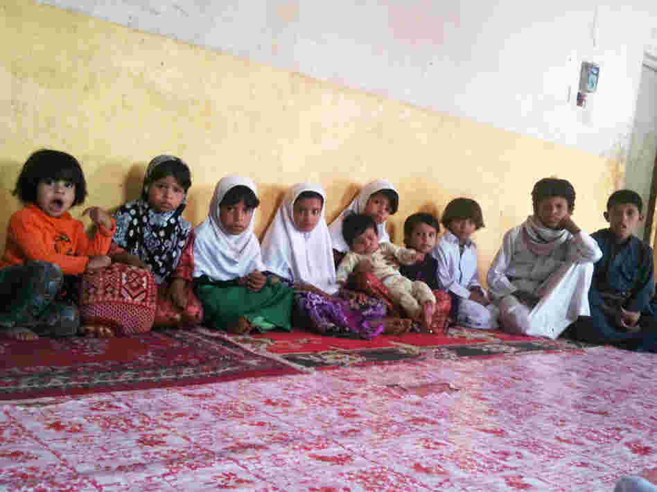 Some of the 26 children of Saleh Qaid Toayman, who was killed with one of his sons in an airstrike on Oct. 14, 2011. The family says the eldest son, Azzedine, has joined an al-Qaida-affiliated group to avenge the father's death. The group's black banner hangs in the family's home. The family says the militant group gives them a monthly stipend.