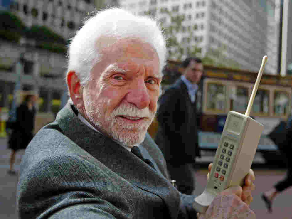 Martin Cooper holds a Motorola DynaTAC, a 1973 prototype of the first hand-held cellular telephone, in San Francisco in 2003. Cooper made the world's first public call from a cellphone in 1973.